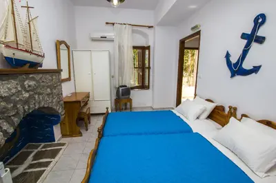 a bedroom with a bed and a fireplace at Symi Center Hotel in Symi
