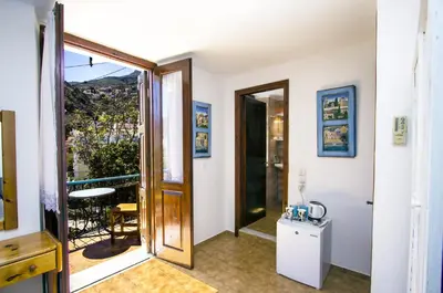 a room with a door leading to a balcony at Symi Center Hotel in Symi
