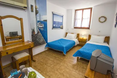 a hotel room with two beds and a mirror at Symi Center Hotel in Symi