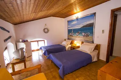 a bedroom with two beds and a painting on the wall at Symi Center Hotel in Symi