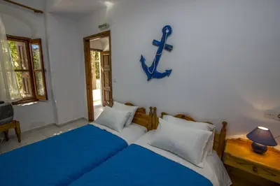 a bedroom with two beds and a anchor on the wall at Symi Center Hotel in Symi