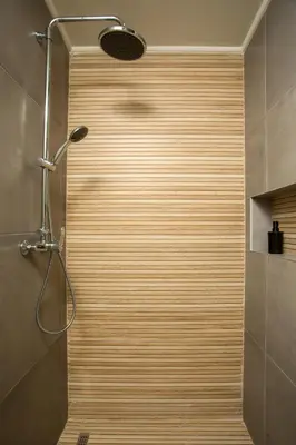 a shower in a bathroom with a wooden wall at Casa Anastasia in Pastida