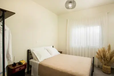 a white bedroom with a bed and a window at Casa Anastasia in Pastida