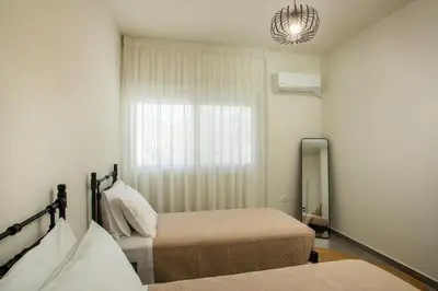 a bedroom with two beds and a mirror and a window at Casa Anastasia in Pastida
