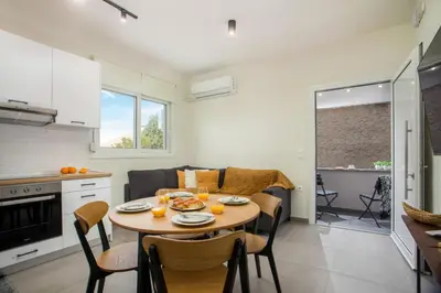 a kitchen and living room with a table and chairs at Casa Anastasia in Pastida