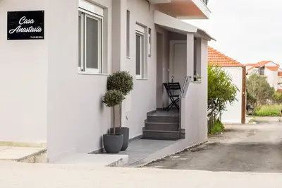 a white house with stairs and a sign on it at Casa Anastasia in Pastida