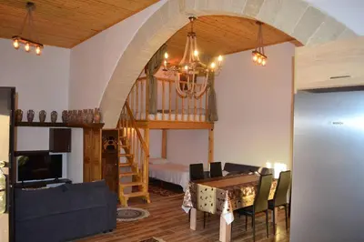a living room with a dining room table and a staircase at michaelas traditional house in Phanaes