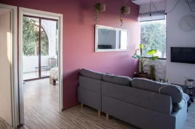 a living room with a couch and a pink wall at mandala central apartment in Rhodes Town