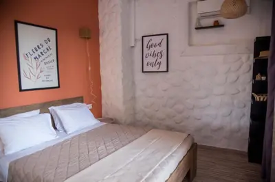 a bedroom with a white bed with two pictures on the wall at mandala central apartment in Rhodes Town