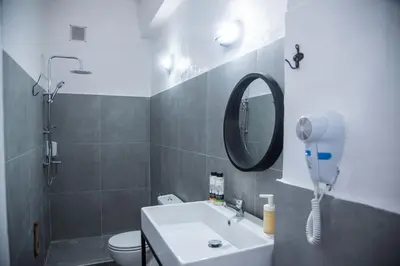 a bathroom with a sink and a mirror and a toilet at mandala central apartment in Rhodes Town