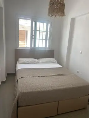 a bed in a white bedroom with a window at Luminous Home City Rhodes in Rhodes Town