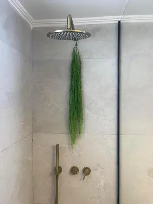a tiled shower with a green tassel on the wall at Luminous Home City Rhodes in Rhodes Town