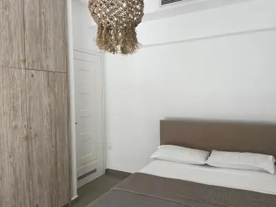 a bedroom with a bed and a chandelier at Luminous Home City Rhodes in Rhodes Town