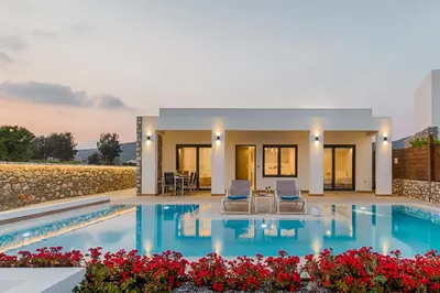 a villa with a swimming pool and two chairs at Prasonisi Villas in Kattavía