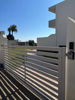 a white fence on the side of a house at Erato Sea View Villa in Koskinou