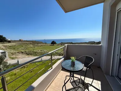 a balcony with a table and a view of the ocean at Erato Sea View Villa in Koskinou