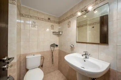 a bathroom with a sink and a toilet and a mirror at Stavroulas Amazing House in Phanaes
