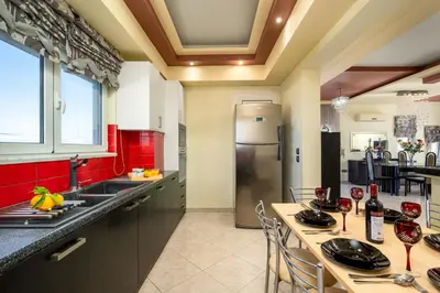a kitchen with a refrigerator and a table with chairs at Stavroulas Amazing House in Phanaes