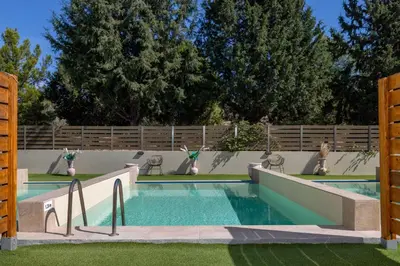 a swimming pool in a yard with a fence at M&B Luxury Suites Charaki in Haraki