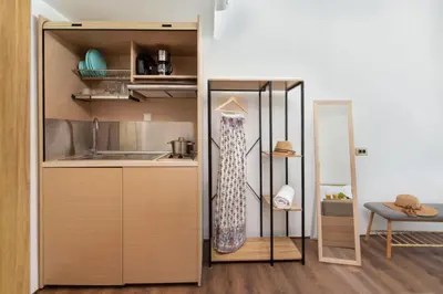 a kitchen with a open cabinet with a sink at M&B Luxury Suites Charaki in Haraki