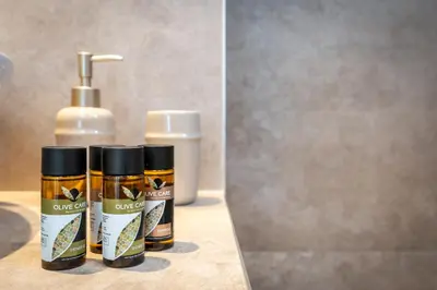 two bottles of cleaning products sitting next to a mirror at M&B Luxury Suites Charaki in Haraki