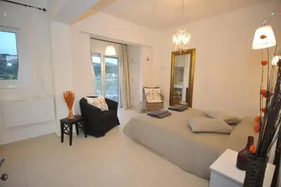 a bedroom with a bed and a chair and a mirror at Villa Sephora in Faliraki
