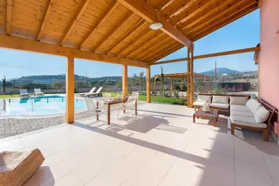 an outdoor patio with a table and chairs and a pool at Villa Sephora in Faliraki