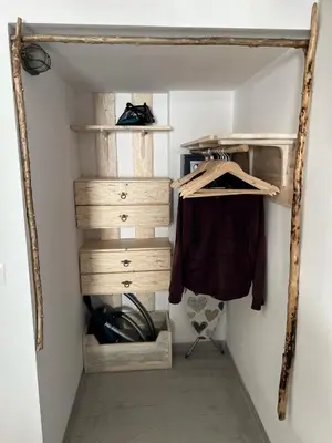 a closet with wooden drawers and a shirt hanging at Ageri & Tritonis Luxury Apartments in Pefki Rhodes