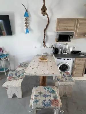 a kitchen with a table and chairs and a stove at Ageri & Tritonis Luxury Apartments in Pefki Rhodes