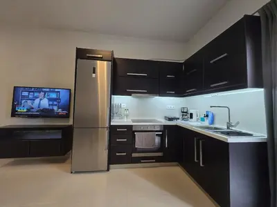 a kitchen with a refrigerator and a tv in it at Konnet Apartment #2 in Rhodes Town