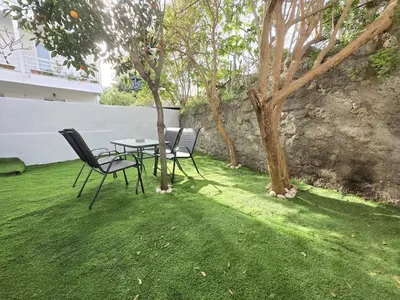 two chairs and a table in a yard with a tree at Konnet Apartment #2 in Rhodes Town