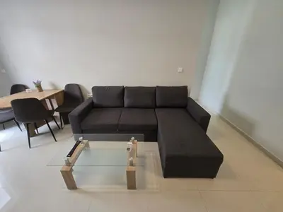 a living room with a black couch and a table at Konnet Apartment #2 in Rhodes Town
