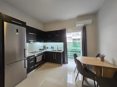 a kitchen with a table and a stainless steel refrigerator at Konnet Apartment #2 in Rhodes Town