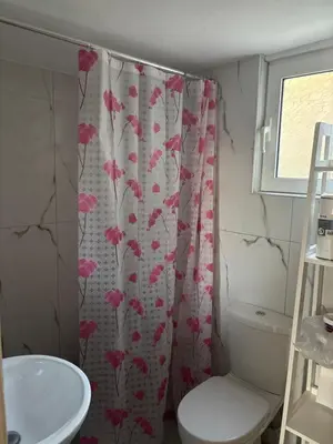a bathroom with a shower curtain with pink flowers on it at rosi rhodos in Rhodes Town