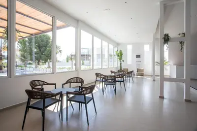 a group of tables and chairs in a room with windows at Lime Hotel Faliraki in Faliraki