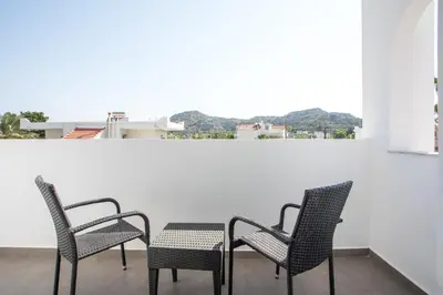 three chairs and a table on a balcony at Lime Hotel Faliraki in Faliraki
