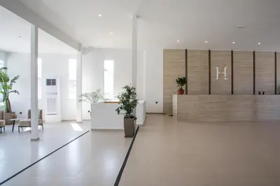 an office lobby with a reception desk and potted plants at Lime Hotel Faliraki in Faliraki