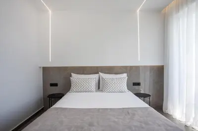 a bedroom with a large bed with white sheets and pillows at Lime Hotel Faliraki in Faliraki