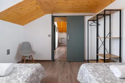 a bedroom with two beds and a wooden ceiling at Kostas Nest in Ialyssos