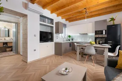 a kitchen and living room with a table and a couch at Kostas Nest in Ialyssos