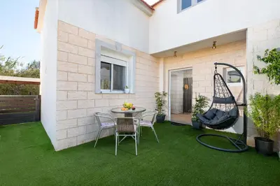 a patio with green grass and a table and chairs at Kostas Nest in Ialyssos
