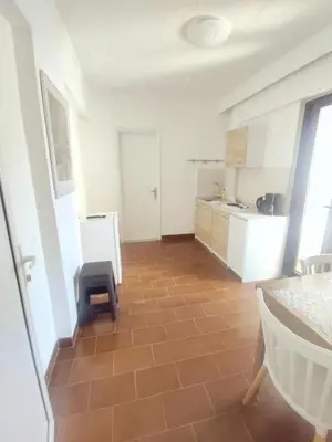 a kitchen with a brown tiled floor and a chair at Apartment in Rhodes town and near the beach in Rhodes Town
