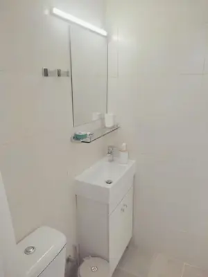 a white bathroom with a toilet and a mirror at Apartment in Rhodes town and near the beach in Rhodes Town