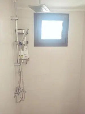 a bathroom with a glass shower with a window at Apartment in Rhodes town and near the beach in Rhodes Town