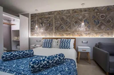 a hotel room with a bed and a chair at Paradise City Apartment in Rhodes Town