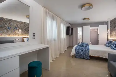 a bedroom with a bed and a desk with a mirror at Paradise City Apartment in Rhodes Town