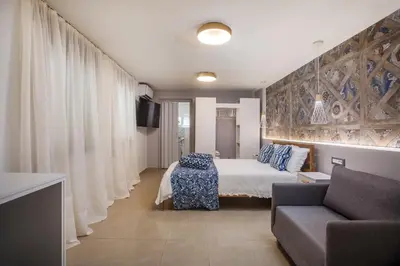 a hotel room with a bed and a couch at Paradise City Apartment in Rhodes Town