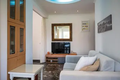 a living room with a couch and a tv at Eln's Sunlit Apartment in Rhodes Town