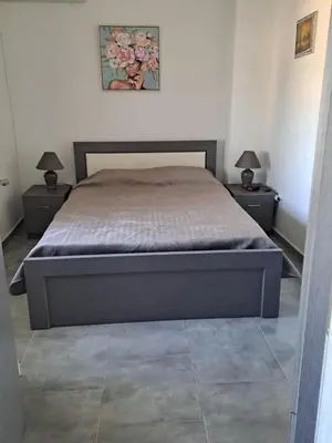 a bedroom with a bed with two nightstands and two lamps at House of Happiness Rhodos in Kritinía