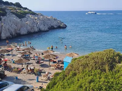 a group of people on a beach with umbrellas at House of Happiness Rhodos in Kritinía